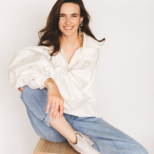 woman in cream top and jeans